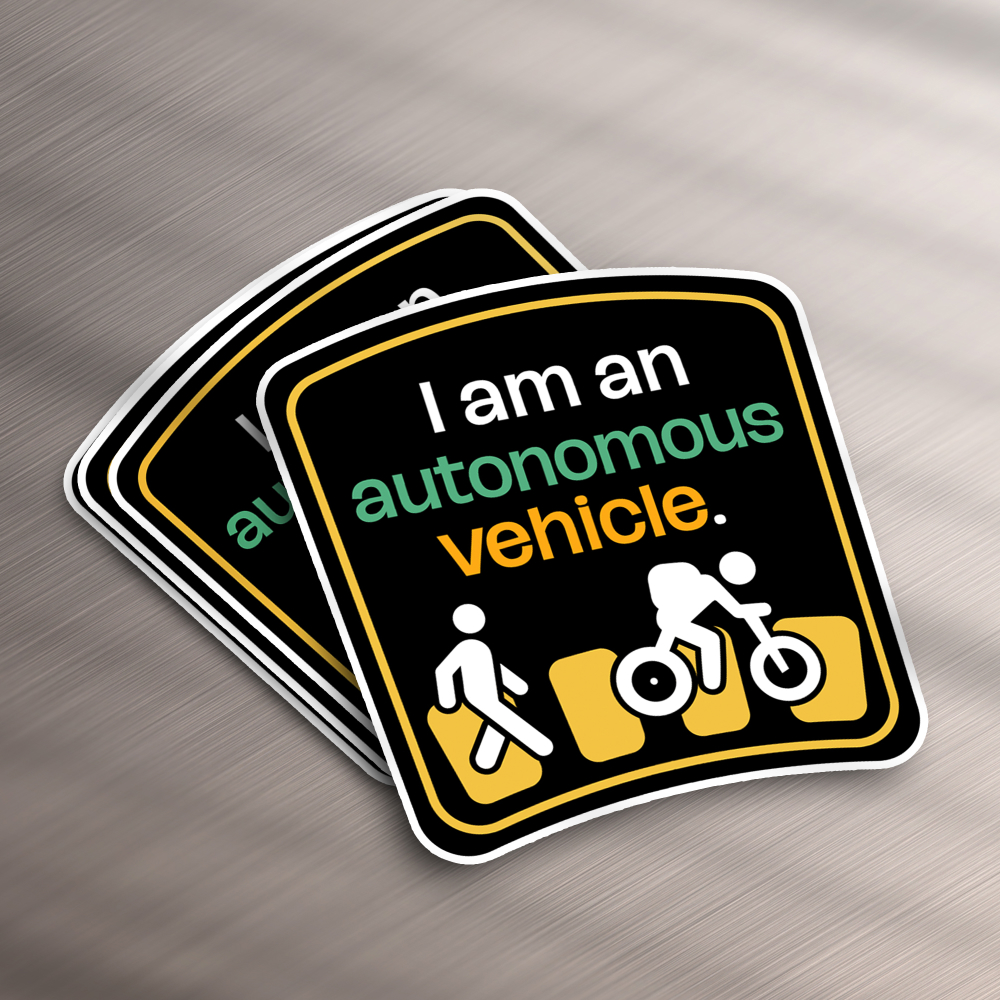 Full service 16 These stickers, perfect for a design subscription, flaunt a traffic-themed motif with I am an autonomous vehicle in white, green, and orange. Below this text, icons depict a pedestrian, cyclist, and car against a black backdrop framed in white.